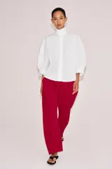 Camisa blanca de algodón de la colección ZW Collection de Zara, con cuello alto, mangas abullonadas por debajo del codo y cierre frontal con botones ocultos por solapa.