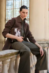 Chaqueta color chocolate de simil gamuza, con cuello camisero, botones frontales y bolsillos laterales.