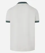 Remera polo comfort color crudo, de manga corta con ribete verde y cuello en V con ribete verde. Tiene un pequeño logo bordado en el pecho.