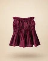 Minifalda de lino color bordó, con diseño fruncido en la cintura y el cuerpo, y ruedo con volado.