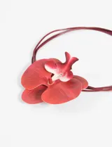 Gargantilla con cordones de cuero sintético color bordó y dije de flor de orquídea roja con detalles en blanco.