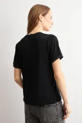 Remera negra de manga corta con escote en V y sutil detalle de lurex brillante en el cuello y las mangas.