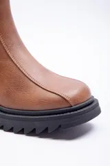Bota corta de cuero sintético color suela, con punta redonda y suela track negra de plataforma de 6 cm.