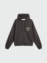 Buzo con cierre frontal y capucha, color gris oscuro, con estampado gráfico en el pecho que incluye la palabra DREAM y detalles de la marca.