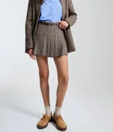 Short pollera de sastre con diseño de cuadros, presenta pliegues marcados y cintura recta. Incluye un cinturón ajustable con hebilla metálica y cuenta con estructura de short por debajo.
