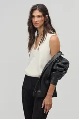 Chaleco tejido color crema con escote en V y terminaciones de rib.