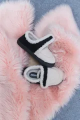 Pantuflas marrones con interior de corderito color crema y ajuste con velcro.