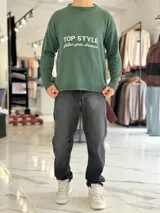 Sweater de punto color beige con cuello redondo, manga larga y diseño estampado en el pecho con las frases "TOP STYLE" y "follow your dreams" en color marrón.