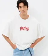 Remera de algodón blanca de corte overboxy, con cuello redondo, manga corta y estampa frontal de lettering en color rojo.