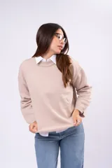 Sweater de punto liso en color beige, con cuello redondo, mangas largas y calce relajado.