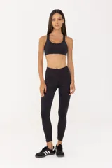 Top deportivo negro con espalda abierta y breteles finos. Cuenta con una banda inferior en la cintura y espacio para agregar tazas.