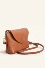 Cartera tipo sobre de cuero color marrón, con solapa frontal redondeada que presenta un detalle circular grabado. Incluye correa larga ajustable y extraíble, cierre principal y broche de seguridad.