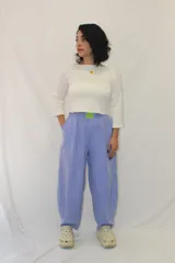 Pantalón de corte holgado y estilo relajado, color lila, con cintura elástica y un aplique decorativo de acrílico en el frente.