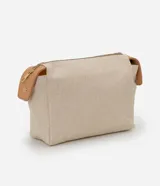 Neceser rectangular grande de color beige claro con textura de tejido canvas, cierre superior con cremallera dorada y detalles de cuero sintético color camel en los extremos.