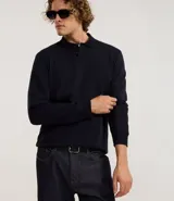 Buzo de algodón color azul marino, de manga larga y cuello polo con botones. Presenta puños y bajo ajustados.