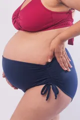 Bombacha de bikini maternal de tiro alto, color azul marino, con frunce lateral ajustable mediante lazos. Cuenta con forro frontal y protección UV.