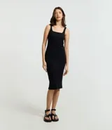 Vestido midi de corte ajustado confeccionado en tejido rib acanalado. Presenta escote cuadrado y breteles anchos, con un diseño básico y minimalista.