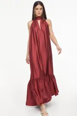 Vestido largo de viscosa color bordó, con cuello halter alto, corte holgado y volante fruncido en el bajo.