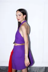 Falda corta de lino con lurex negro y plateado, de diseño cruzado estilo pareo con cierre invisible lateral y detalle de lazo asimétrico.
