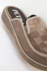 Zueco marrón de cuero con plataforma y detalle de tiras entretejidas en el empeine.