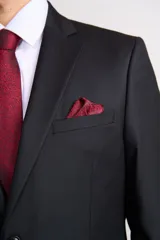 Traje de dos piezas compuesto por saco de corte clásico con cierre de un botón y pantalón de vestir a juego. Presenta solapas de muesca y bolsillos con solapa.