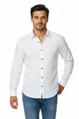 Camisa de algodón color blanco, de corte holgado, con cuello camisero y cierre frontal de botones.