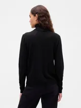 Buzo de punto con cuello alto tipo polera, de corte ajustado y manga larga.