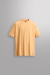 Camiseta deportiva color naranja confeccionada en tejido técnico, ligero y elástico. Tiene cuello redondo, mangas cortas y logo estampado.