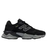 Championes urbanos New Balance modelo 9060, color negro con detalles en gris. Presentan un diseño robusto con tecnología Cordura, combinando materiales de gamuza y malla, con el logo N característico en los laterales y una entresuela esculpida de gran volumen.