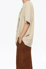 Camiseta de algodón orgánico color negro con efecto gastado, corte oversize y manga corta ancha. Presenta un estampado artístico enmarcado con el texto "BIMBA Y LOLA" en la parte superior e inferior.