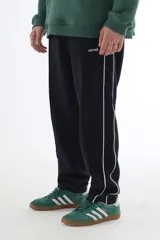 Pantalón de jogging negro de felpa con corte recto, tiro medio, línea lateral blanca y logo VERNAL bordado.