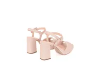 Sandalias de cuero color nude con taco de 10 cm y plataforma de 2 cm. Presentan tiras sin costuras y cierre de hebilla en el tobillo.
