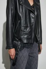 Campera estilo biker de cuero sintético negro, con solapas amplias, cierre frontal asimétrico, bolsillos laterales con cierre y cinturón ajustable en la cintura.
