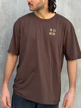 Remera marrón de corte oversize con estampado pequeño en el pecho.