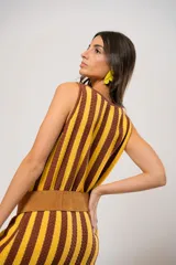 Vestido corto tejido a rayas verticales color amarillo y marrón, con escote redondo y mangas sisa. Incluye cinturón marrón con hebilla dorada.