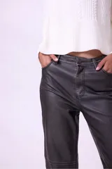 Pantalon de corte recto confeccionado en material con efecto piel, color gris oscuro. Presenta costuras horizontales a la altura de las rodillas, cierre frontal con botón y bolsillos laterales.