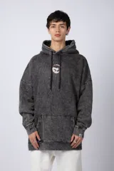 Buzo canguro oversize de algodón friza con efecto de teñido artesanal acid wash en color gris oscuro. Presenta capucha con cordones ajustables, bolsillo frontal tipo canguro y estampa pequeña en el pecho.