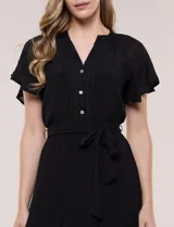 Vestido midi blanco de calce suelto y caída fluida, con escote en V, cuello a la base y apertura abotonada con detalle de puntilla. Cuenta con cintura elastizada con lazo para anudar a tono, mangas cortas con volados y falda con volantes escalonados.