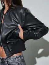 Campera bomber de eco cuero negro, con cierre frontal plateado, cuello, puños y cintura elastizados en rib.