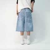 Bermuda baggy de denim color celeste, corte holgado y diseño largo por debajo de las rodillas. Cuenta con múltiples bolsillos traseros, presillas para cinturón y detalle de bordado en uno de los bolsillos.