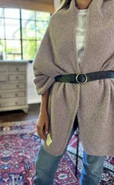 Chal de punto bouclé color marrón claro, hecho de 100% baby alpaca. Tejido suave, esponjoso y cálido, ofrece una textura envolvente y lujosa.