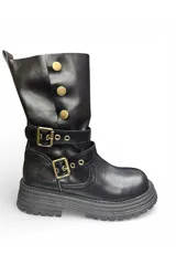 Bota alta color negro de diseño slouchy, con suela track gruesa y dos tiras con hebillas metálicas doradas en la zona del empeine y tobillo. Cuenta con tres botones metálicos decorativos en la parte superior lateral.