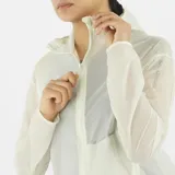 Campera cortavientos de mujer Salomon Sense Aero Wind, ultraligera y transpirable, color blanco semitransparente, con capucha y cierre frontal completo.