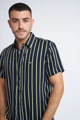 Camisa de manga corta con diseño a rayas verticales en color azul marino y blanco. Presenta cuello clásico, cartera abotonada frontal y logo bordado en el pecho. Posee un corte slim fit.