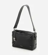 Cartera tipo shoulder de tamaño mediano, confeccionada en poliuretano con diseño rectangular. Presenta correas laterales decorativas con remaches metálicos, cierre superior con cremallera, herrajes en acabado gunmetal y correa larga ancha ajustable.