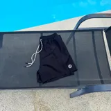 Short de baño negro con cintura elástica y cordón ajustable bicolor. Presenta un parche circular con logo en la parte inferior de la pierna.
