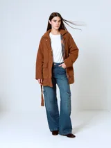 Campera de pana color marrón, con diseño acolchado, cuello camisero, cierre frontal oculto y cinturón ajustable con hebilla a tono. Presenta bolsillos frontales con solapa y mangas largas de corte holgado.