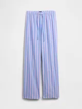 Pijama de dos piezas confeccionado en popelina, compuesto por una camisa de manga corta con cuello solapa y cierre frontal de botones, y un pantalón largo de corte recto con cintura elástica. Presenta un estampado integral de cerezas sobre fondo rosado.