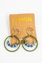 Aros colgantes formados por una argolla superior dorada, un aro grande esmaltado en color verde oliva y un aro interno dorado decorado con cuentas de cristal en tonos azules y verdes.