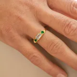 Anillo de plata 925 bañada en oro 18k con una piedra central de topacio azul rectangular y una esmeralda circular a cada lado.